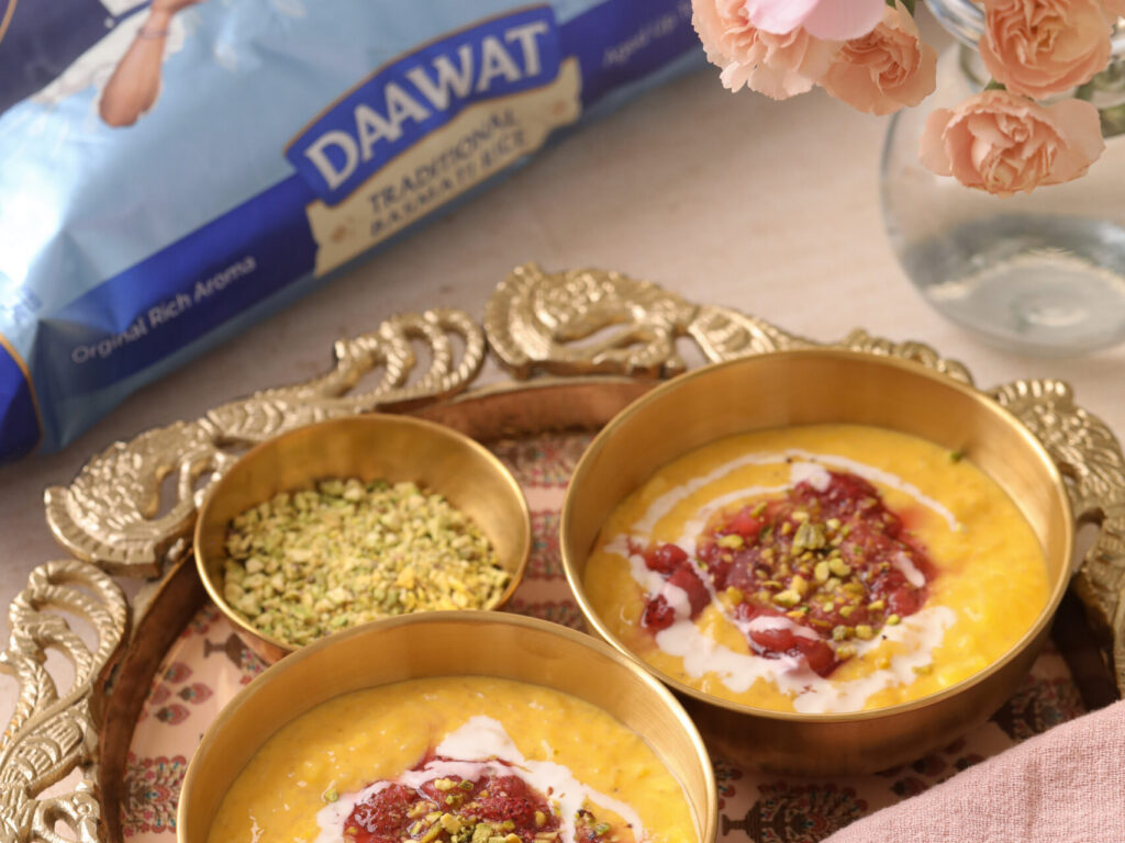 Mango Kheer with Jammy Strawberries served in brass bowls with crushed pistachios, topped with strawberry compote, alongside Daawat Traditional Basmati Rice