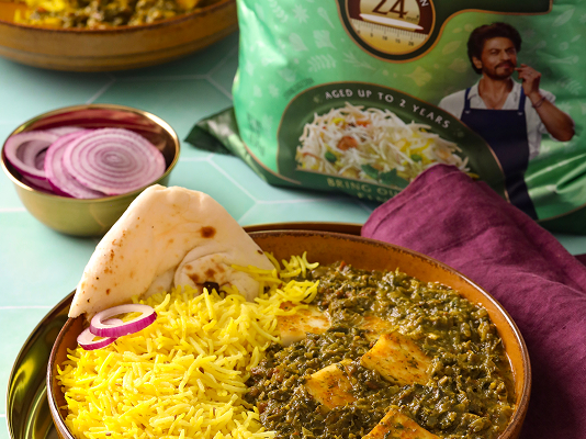 Saag Paneer served with yellow basmati rice, garnished with red onion and naan, alongside Daawat Ultima Basmati Rice