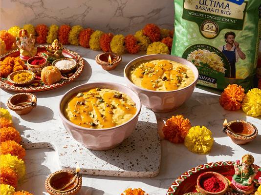 Mango Lassi Kheer garnished with chopped pistachios and saffron, served in pink bowls alongside Daawat Ultima Basmati Rice, festive marigold flowers, diyas, and a traditional puja thali.